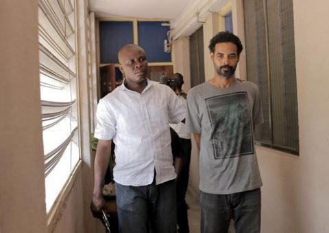 A Ghanaian police officer escorts Arthur Simpson-Kent inside the Criminal Investigation Department headquarters in Accra, Ghana, January 10, 2016. REUTERS/Francis Kokoroko