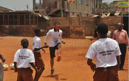 Coach Keni playing soccer with the school kids